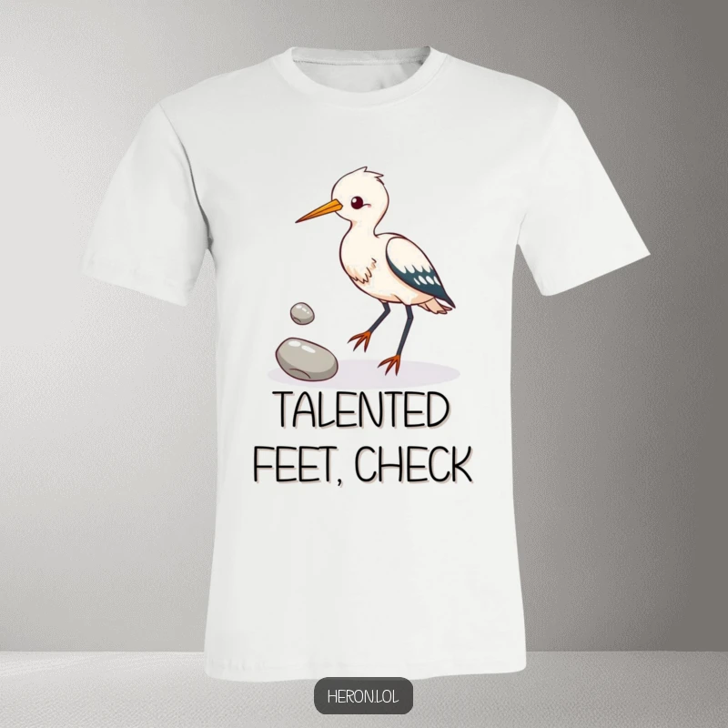 Funny heron bird attempting to juggle three shiny pebbles with its feet, depicted on a humorous t-shirt for bird lovers.