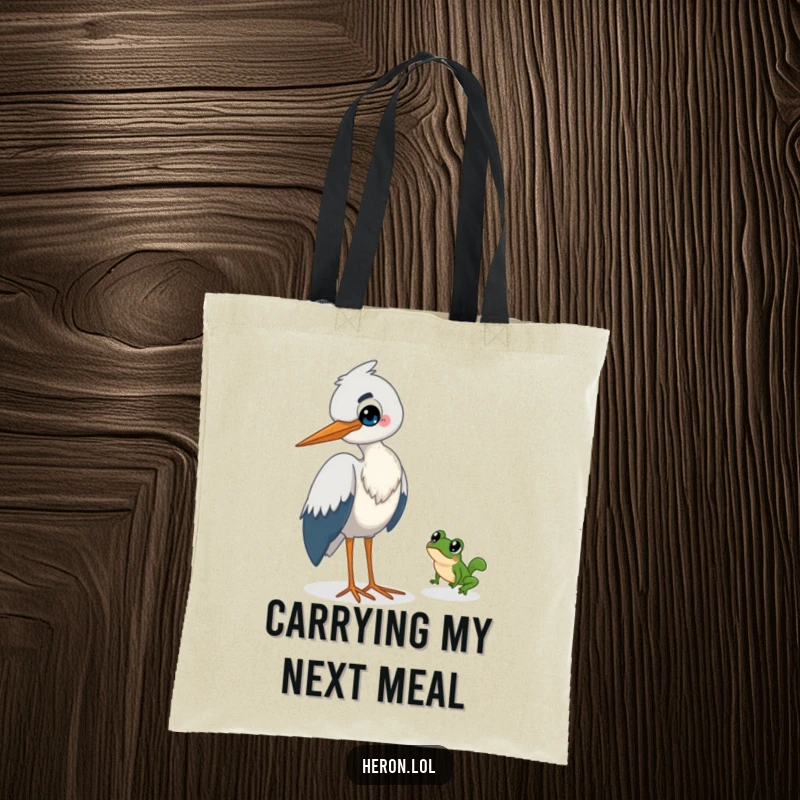 Funny Heron Tote Bag: A mischievous heron watches with a grin as a small frog hops away quickly.